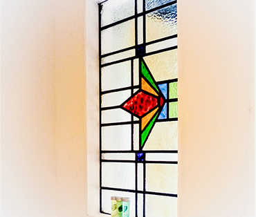 A stained glass window in the bathroom of room two